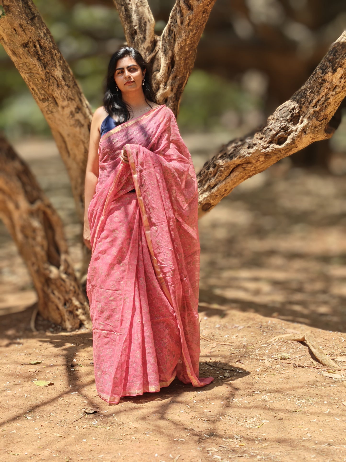 Woman wearing blush pink hand block printed Kota Doria saree in natural light