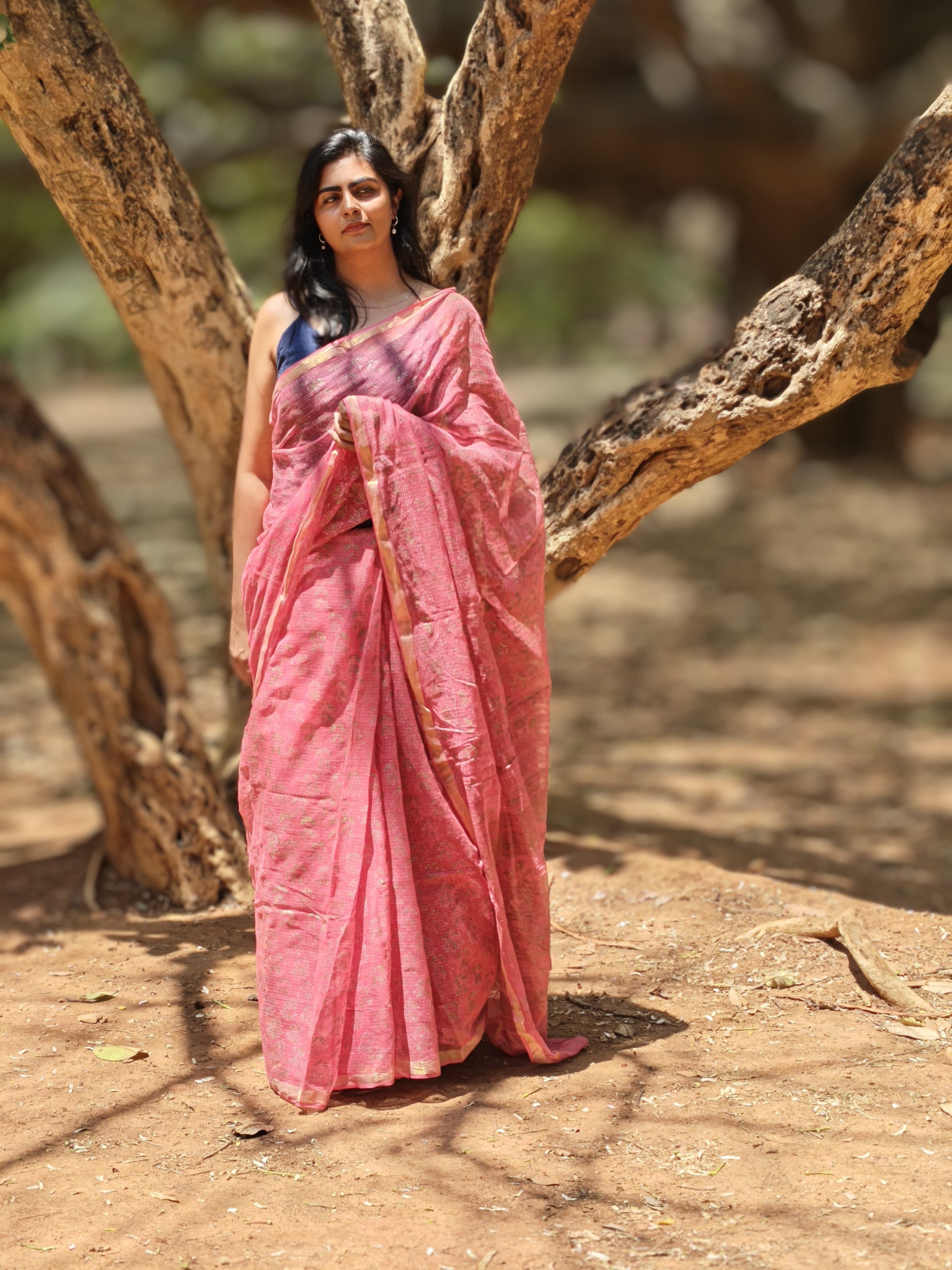 Woman wearing blush pink hand block printed Kota Doria saree in natural light